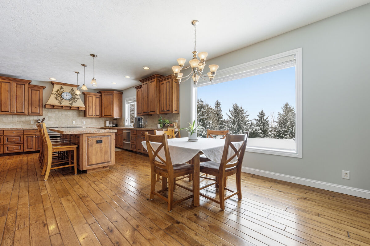 Open dining and kitchen area with panoramic winter mountain views