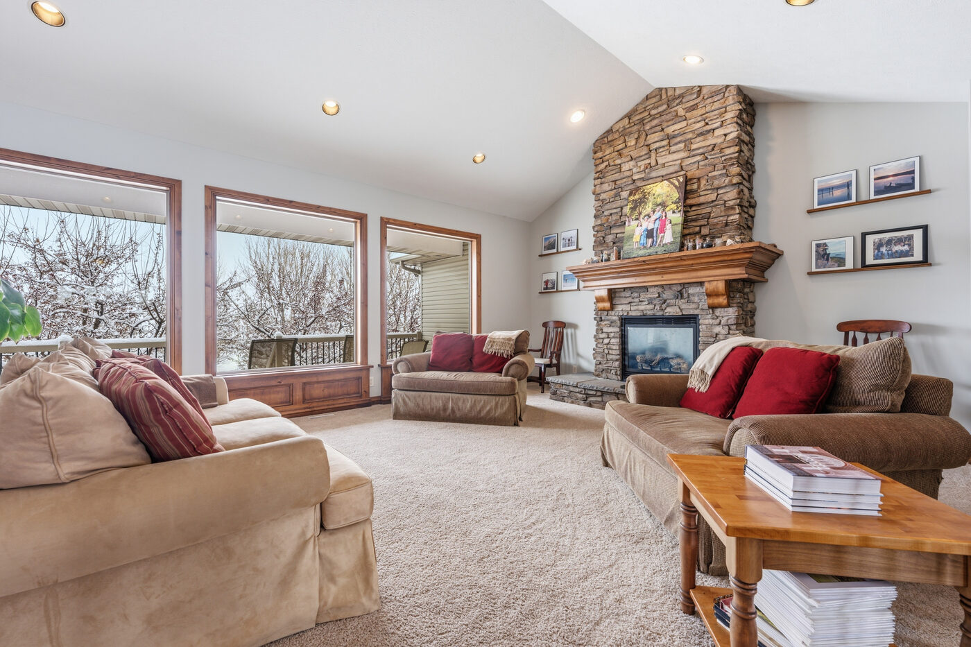 Living room with stone fireplace and vaulted ceiling